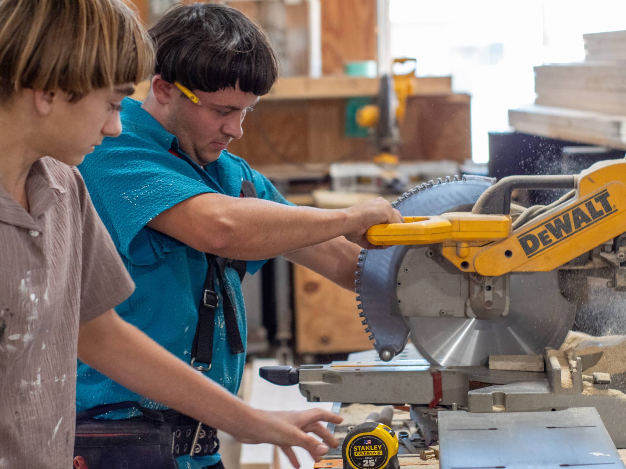 Workers using a power saw to cut wood